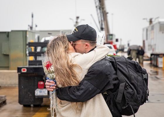 Seaman Fire Control Technician Tanner Hornsby, assigned to the Virginia-class fast-attack submarine USS New Hampshire (SSN 778), kisses his significant other as the traditional first kiss during the boat's homecoming at Naval Station Norfolk, Jan. 17, 2023.