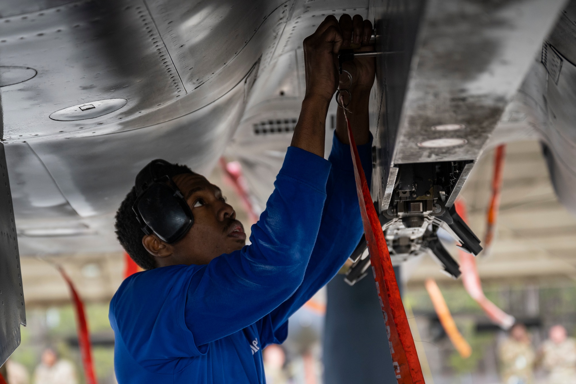 An Airman assigned to the 334th Fighter Generation Squadron tightens a screw on an F-15E Strike Eagle during the 4th Quarter Weapons Load Crew Competition at Seymour Johnson Air Force Base, North Carolina, Jan. 13, 2023. Members of the 4th Maintenance Group participated in the competition to ensure proper weapons handling while racing against the clock.