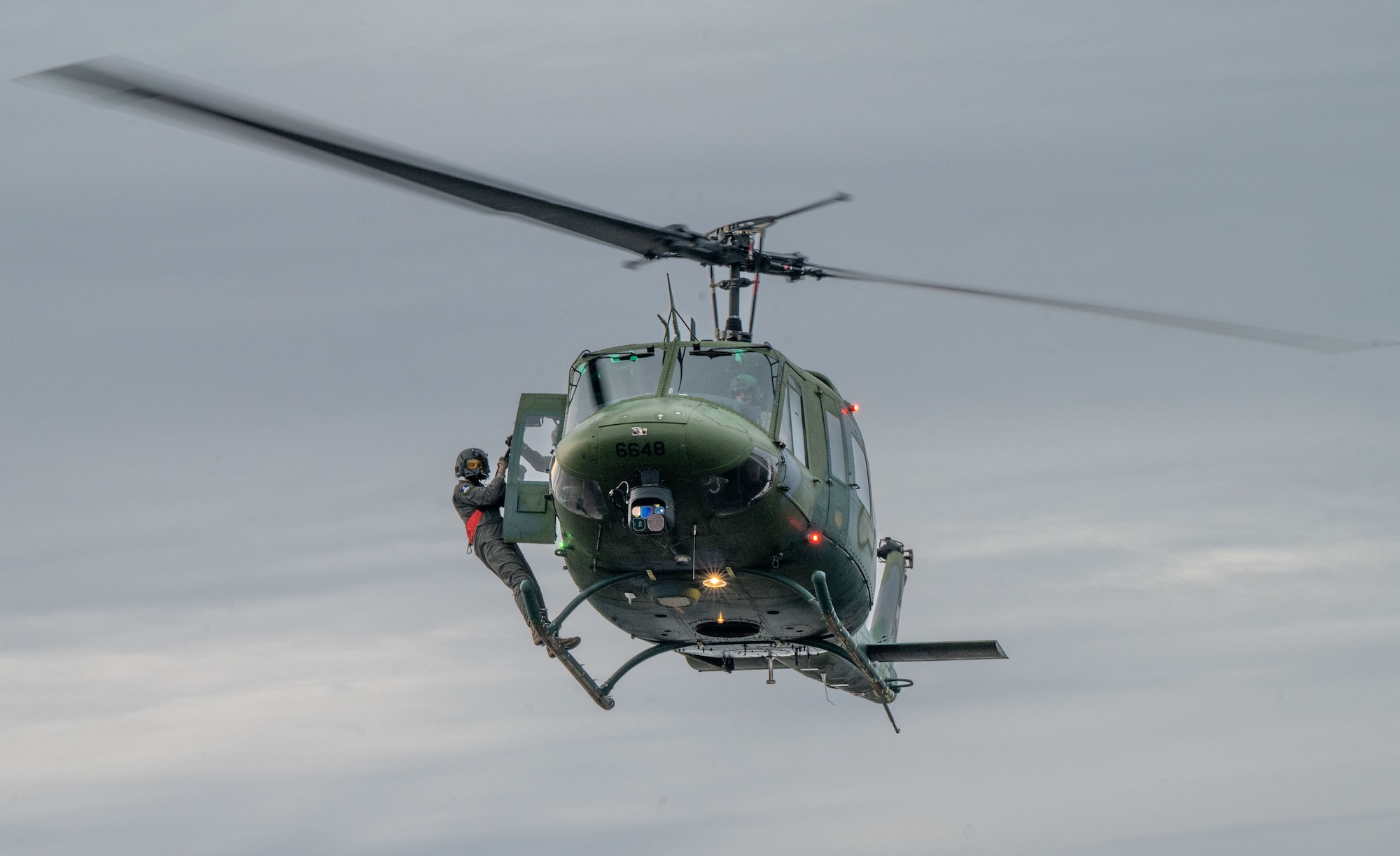 A U.S. Air Force Senior Airman Devin Hackney, 36th Rescue Squadron special mission aviator prepares to hoist from a UH-1N Huey at Fairchild Air Force Base, Washington, Jan. 13, 2023. The UH-1N Huey is a multipurpose utility helicopter famous for its widespread use during the Vietnam War. (U.S. Air Force photo by Airman 1st Class Stassney Davis)