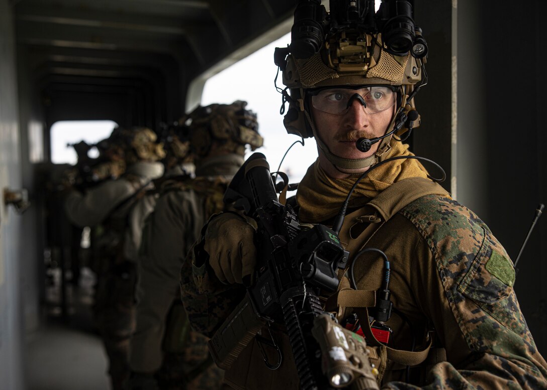 A U.S. Marine with the Maritime Special Purpose Force (MSPF), 26th Marine Expeditionary Unit, patrols a cargo ship during a Visit, Board, Search, and Seizure (VBSS) course at Fort Eustis, Virginia, Jan. 12, 2023. Marines with the MSPF and BLT 1/6 conducted boat assault force operations to further advance their qualifications to conduct VBSS operations during their upcoming deployment with the 26th MEU. The VBSS course is designed by Expeditionary Operations Training Group to train MSPF, BLT 1/6, and supporting enablers across the Marine Air Ground Task Force to conduct Maritime Interception Operations in preparation for the Amphibious Ready Group/Marine Expeditionary Unit (ARG/MEU) deployment. (U.S. Marine Corps photo by Cpl. Matthew Romonoyske-Bean)