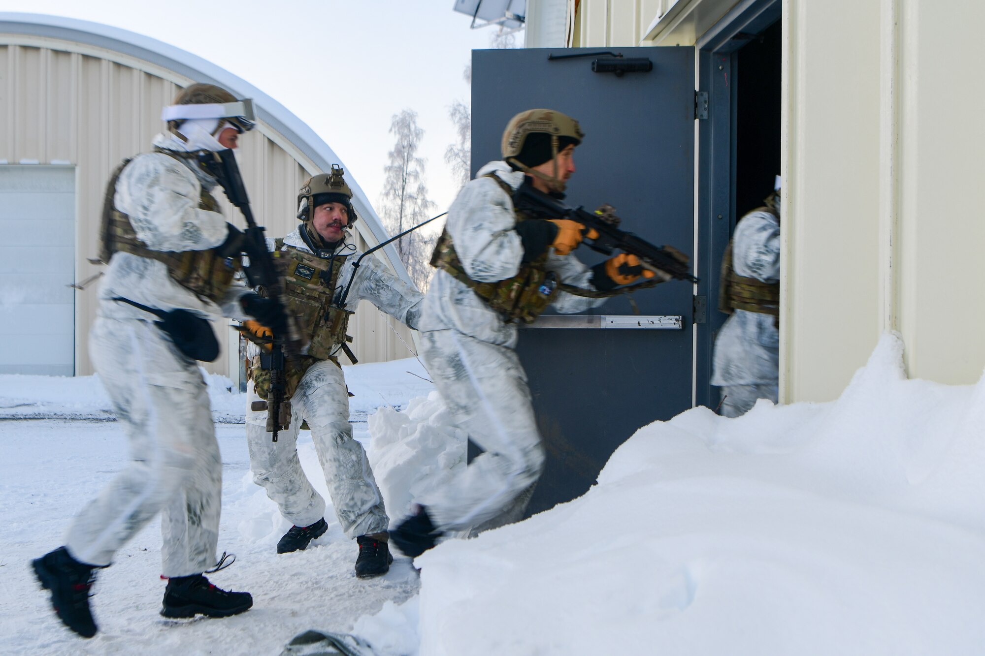 Airmen conduct a simulated combat training in extreme-cold conditions