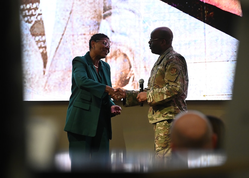 Terri L. Freeman, left, Executive Director of the Reginald F. Lewis Museum of Maryland African American History and Culture, is coined by Col. Todd E. Randolph, 316th Wing and installation commander, during the Remembering Dr. Martin Luther King Jr. Event at Joint Base Andrews, Md., Jan. 18, 2023. Oftentimes, guest speakers and distinguished visitors are coined by senior leadership as a token of appreciation from JBA. (U.S. Air Force photo by Airman 1st Class Austin Pate)