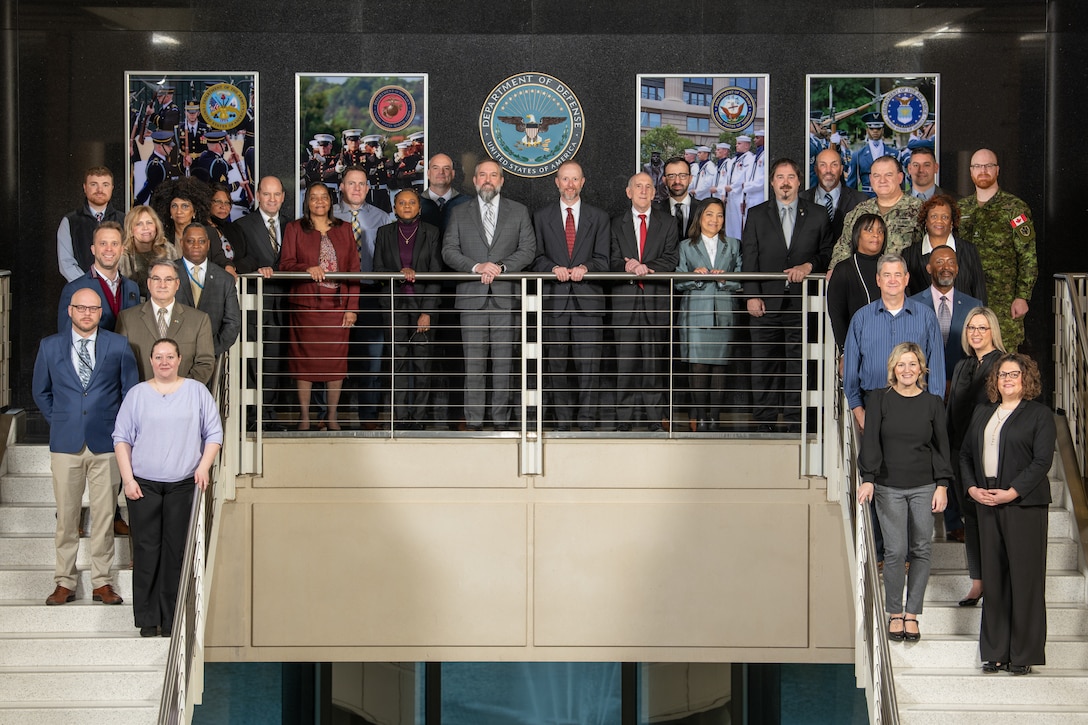 A group of people pose on a staircase.