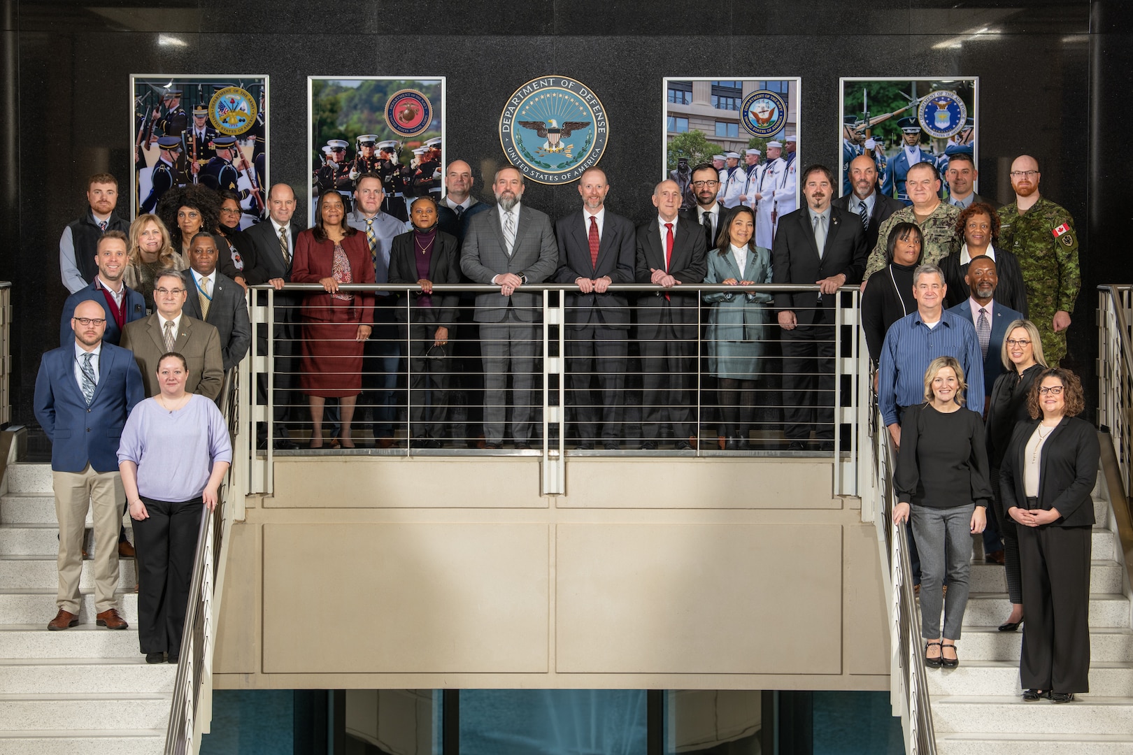 A group of people pose on a staircase.