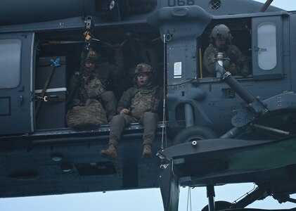 Guard Maritime Security Response Team West members prepare to fast-rope from a 210th Rescue Squadron Alaska Air National Guard HH-60G Pave Hawk combat search and rescue helicopter onto the Coast Guard Cutter Cypress at Kodiak, Alaska, Jan. 11, 2023, during a joint service training exercise. MSRT West members maintain a ready alert force to support Coast Guard operational commanders and Department of Defense combatant commanders.