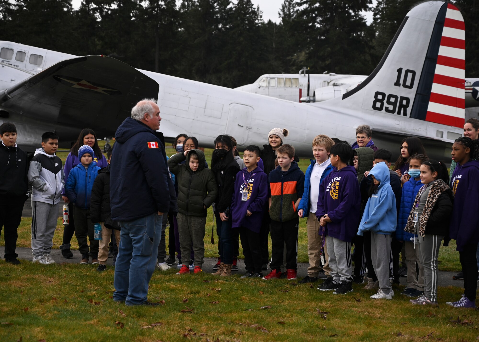 Shon Zawada, McChord Air Museum curator, briefs students from Stafford Elementary School, Tacoma, during an Aviation Inspiration and Mentorship (AIM) tour at Joint Base Lewis-McChord, Washington, Jan. 17, 2023. AIM is a community outreach program that is designed to inform, influence and inspire the next generation of Air Force aviators. (U.S. Air Force photo by Senior Airman Callie Norton)