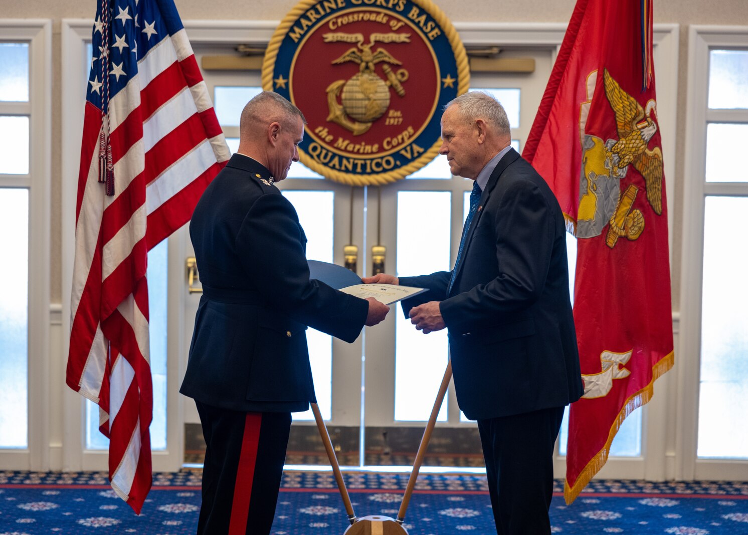 Rick Nealis, director of the Marine Corps Marathon Organization, right, is handed a letter of appreciation by U.S. Marine Corps Major Gen. David Maxwell, commander of Marine Corps Installations Command, left, during his retirement ceremony at The Clubs at Quantico, Virginia, Jan. 18, 2023. Rick Nealis served as the director of the Marine Corps Marathon Organization for 30 years and served as an active duty Marine for 20 years. (U.S. Marine Corps by Lance Cpl. Jeffery Stevens)