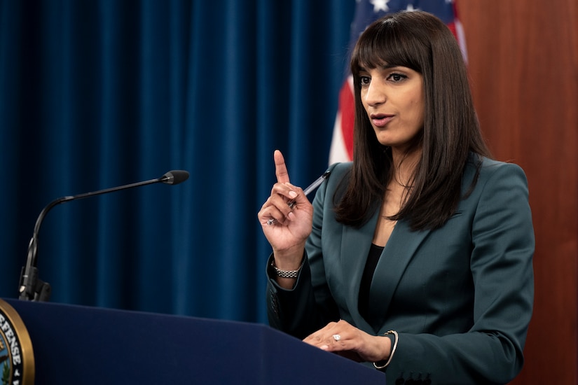 A woman stands behind a lectern.