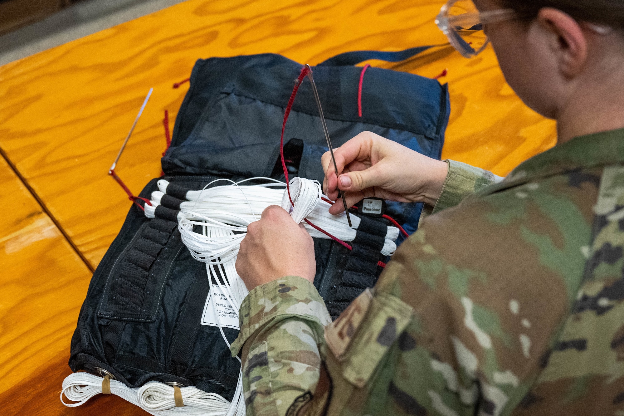 Senior Airman Karlie Kometscher, 15th Operations Support Squadron aircrew flight equipment journeyman, works on a Butler Parachute BA-30 low profile parachute system at Joint Base Pearl Harbor-Hickam, Hawaii, Jan. 11, 2023. AFE technicians are vital in delivering safe and mission-ready support equipment for our Hickam C-17’s and ensuring a free and open Indo-Pacific. (U.S. Air Force photo by Senior Airman Makensie Cooper)