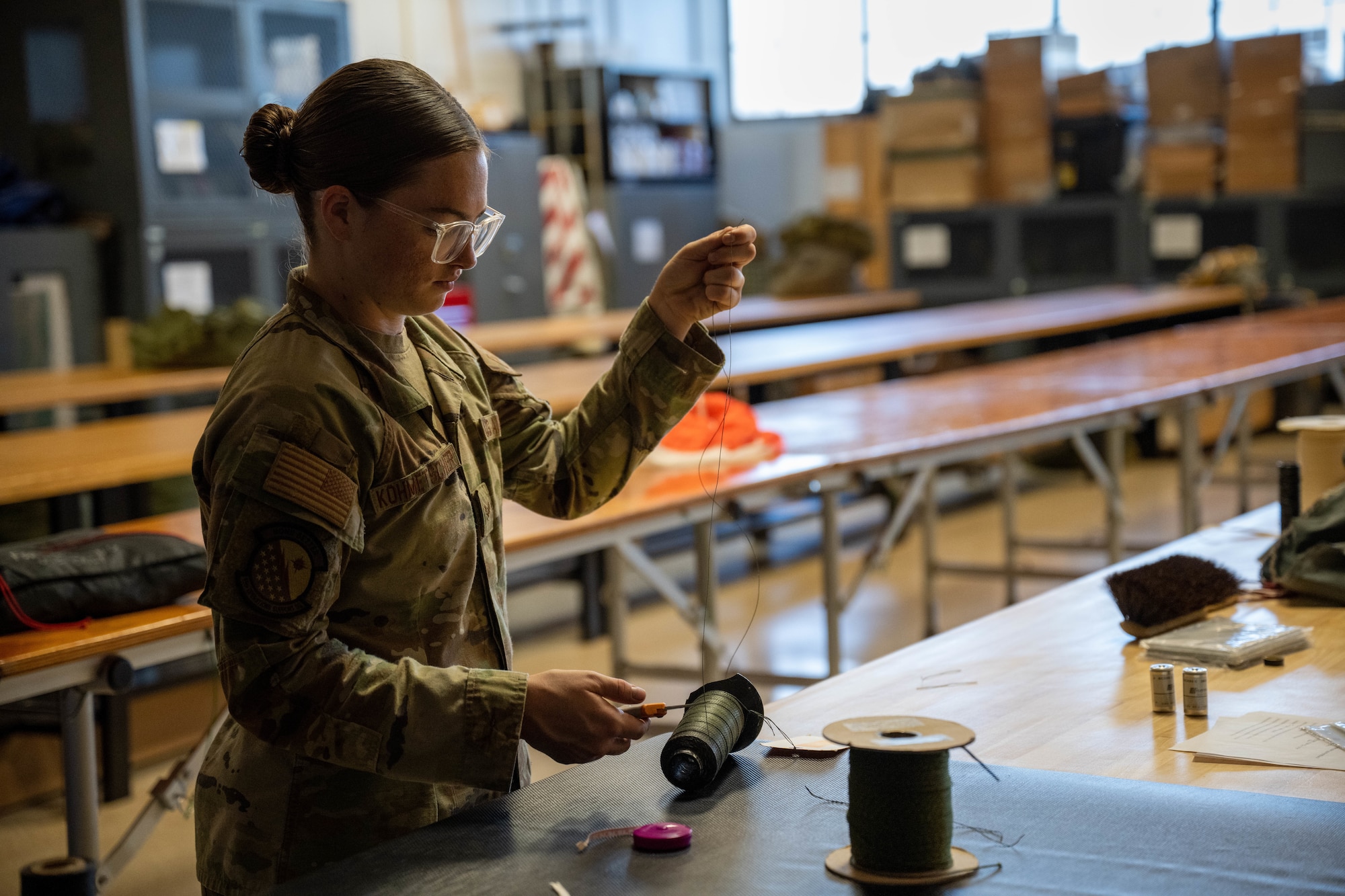 Senior Airman Karlie Kometscher, 15th Operations Support Squadron aircrew flight equipment journeyman, works on a Butler Parachute BA-30 low profile parachute system at Joint Base Pearl Harbor-Hickam, Hawaii, Jan. 11, 2023. AFE technicians are responsible for all emergency floatation devices and parachutes on Hickam aircraft in case of an in-flight emergency. (U.S. Air Force photo by Senior Airman Makensie Cooper)