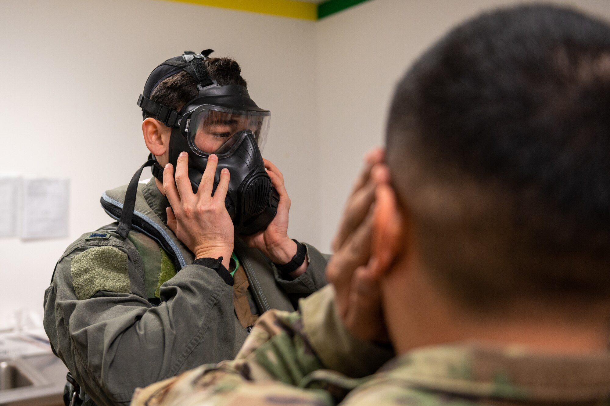 U.S. Air Force Senior Airman Isiah Echevarria, 51st Operations Support Squadron aircrew flight equipment journeyman, ensures U.S. Air Force 1st Lt. Michael Davey, 25th Fighter Squadron A-10C Thunderbolt II pilot, has a tight seal for his M50 respirator mask while participating in a next generation aircrew protection (NGAP) evaluation at Osan Air Base, Republic of Korea, Jan. 18, 2023.