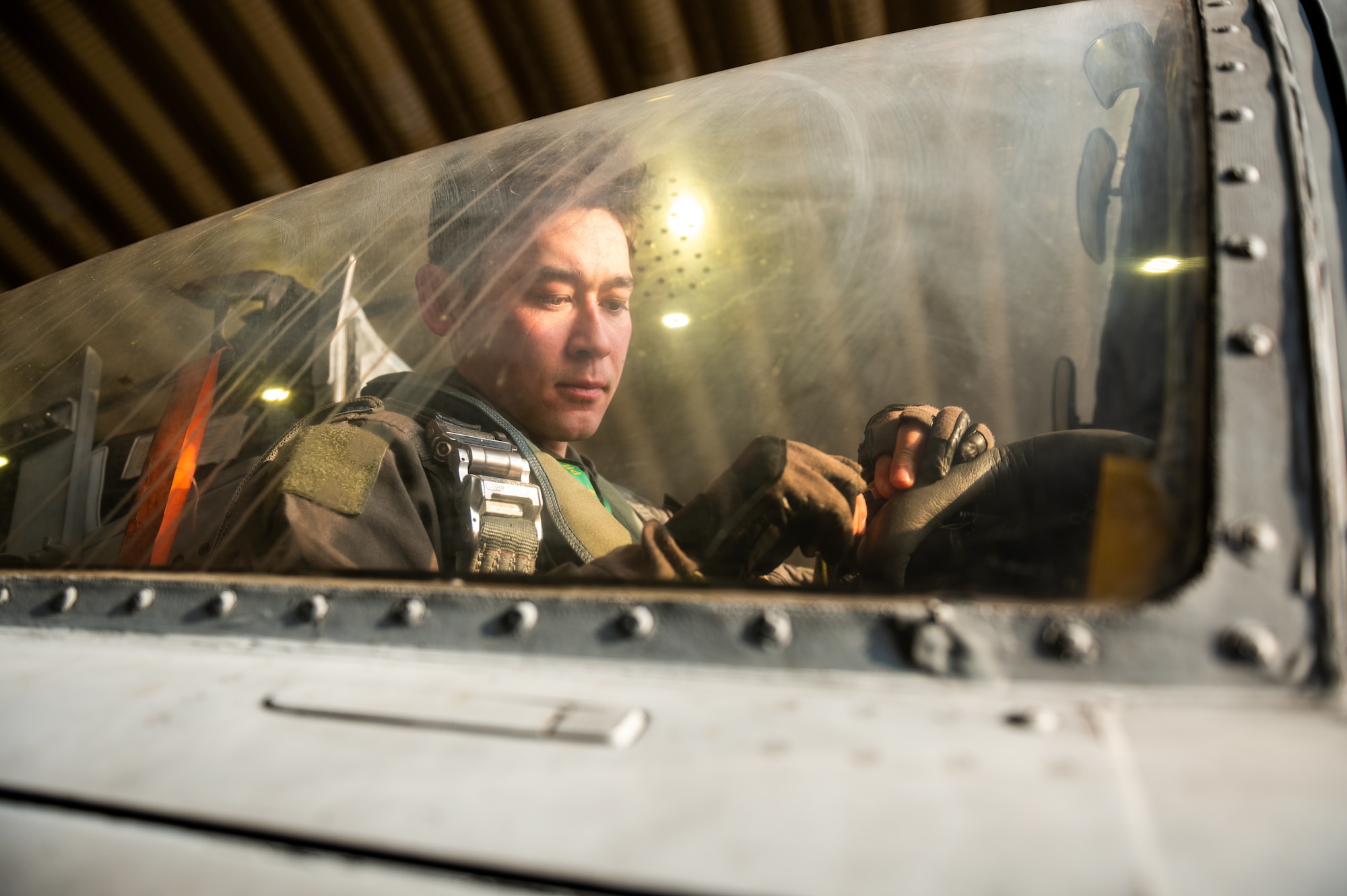 U.S. Air Force 1st Lt. Michael Davey, 25th Fighter Squadron A-10C Thunderbolt II pilot, connects communications equipment to his helmet after removing an M50 respirator mask while participating in a next generation aircrew protection (NGAP) evaluation at Osan Air Base, Republic of Korea, Jan. 18, 2023.