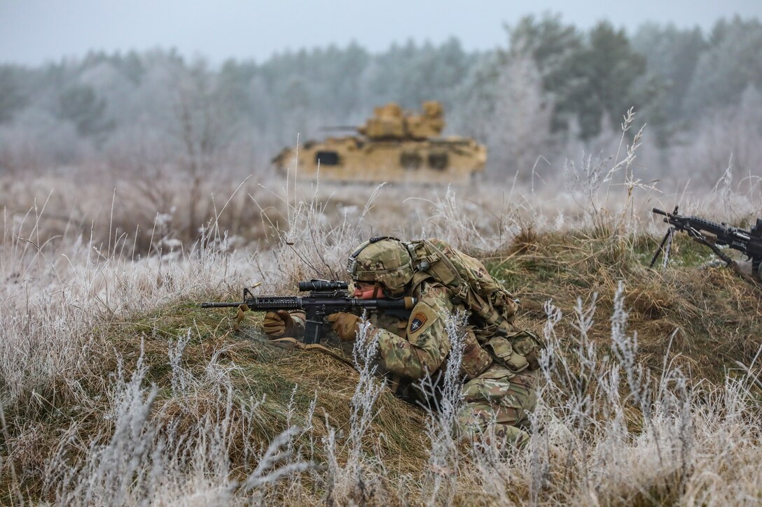U.S. Soldiers assigned to Chaos Company, 3rd Battalion, 8th Cavalry Regiment, 3rd Armored Brigade Combat Team, 1st Cavalry Division (3-1 ABCT) operationally controlled by the 1st Infantry Division (1 ID), engage the simulated target together with a M3 Bradley Fighting Vehicle during the Bull Run live fire exercise in Bemowo Piskie, Poland, Nov. 23, 2022. The 3-1 ABCT is among other units assigned to the 1 ID, proudly working alongside NATO allies and regional security partners to provide combat-credible forces to V Corps, America's forward deployed corps in Europe. (U.S. Army National Guard photo by Staff Sgt. Matthew A. Foster)
