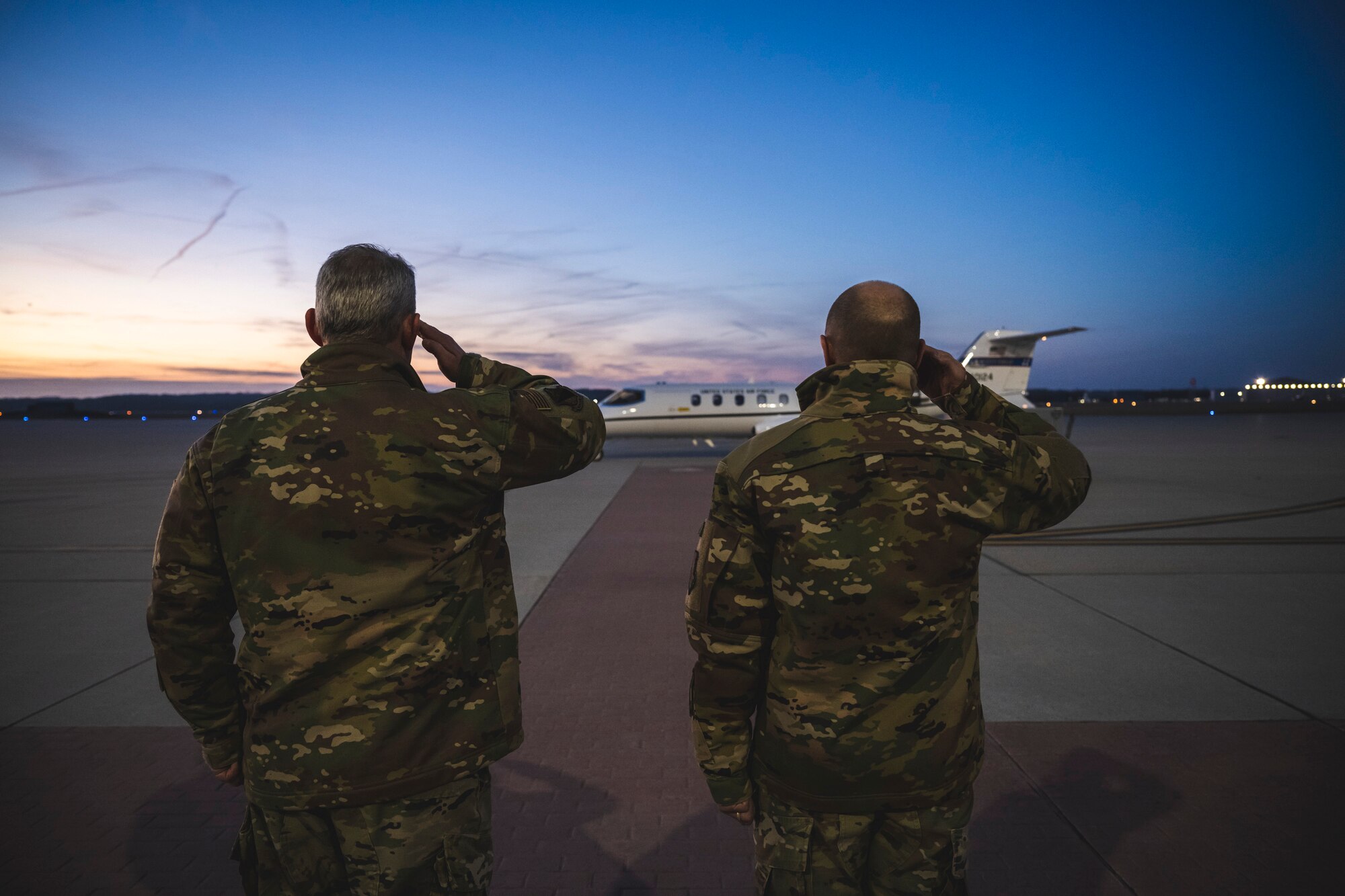 Col. Christopher Meeker (left), 88th Air Base Wing commander, and Lt. Gen. Carl Schaefer, Air Force Materiel Command deputy commander, salute Jan. 9 as the jet carrying Gina Ortiz Jones, undersecretary of the Air Force, prepares for takeoff from Wright-Patterson Air Force Base, Ohio.