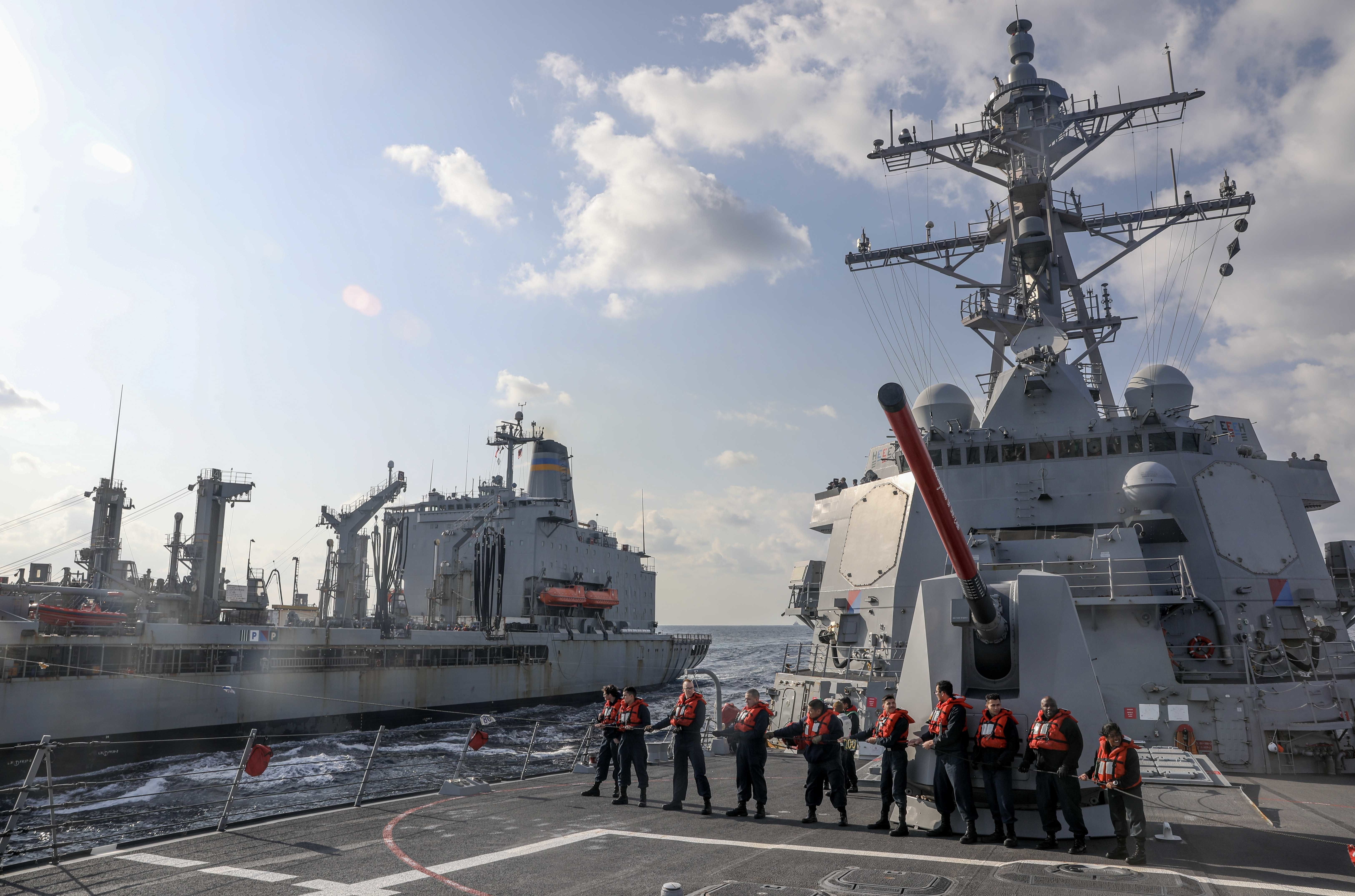 Sailors assigned to the Arleigh Burke-class guided-missile destroyer USS Rafael Peralta (DDG 115) steady a phone-and-distance line during an underway replenishment with the Military Sealift Command Henry J. Kaiser-class fleet replenishment oiler USNS John Ericsson (T-AO 194) in the Philippine Sea.