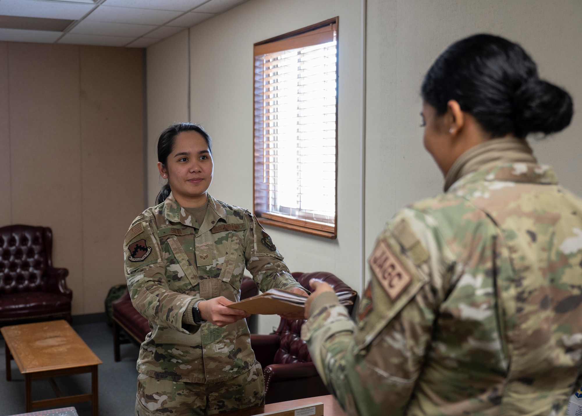Two Airmen pass documents