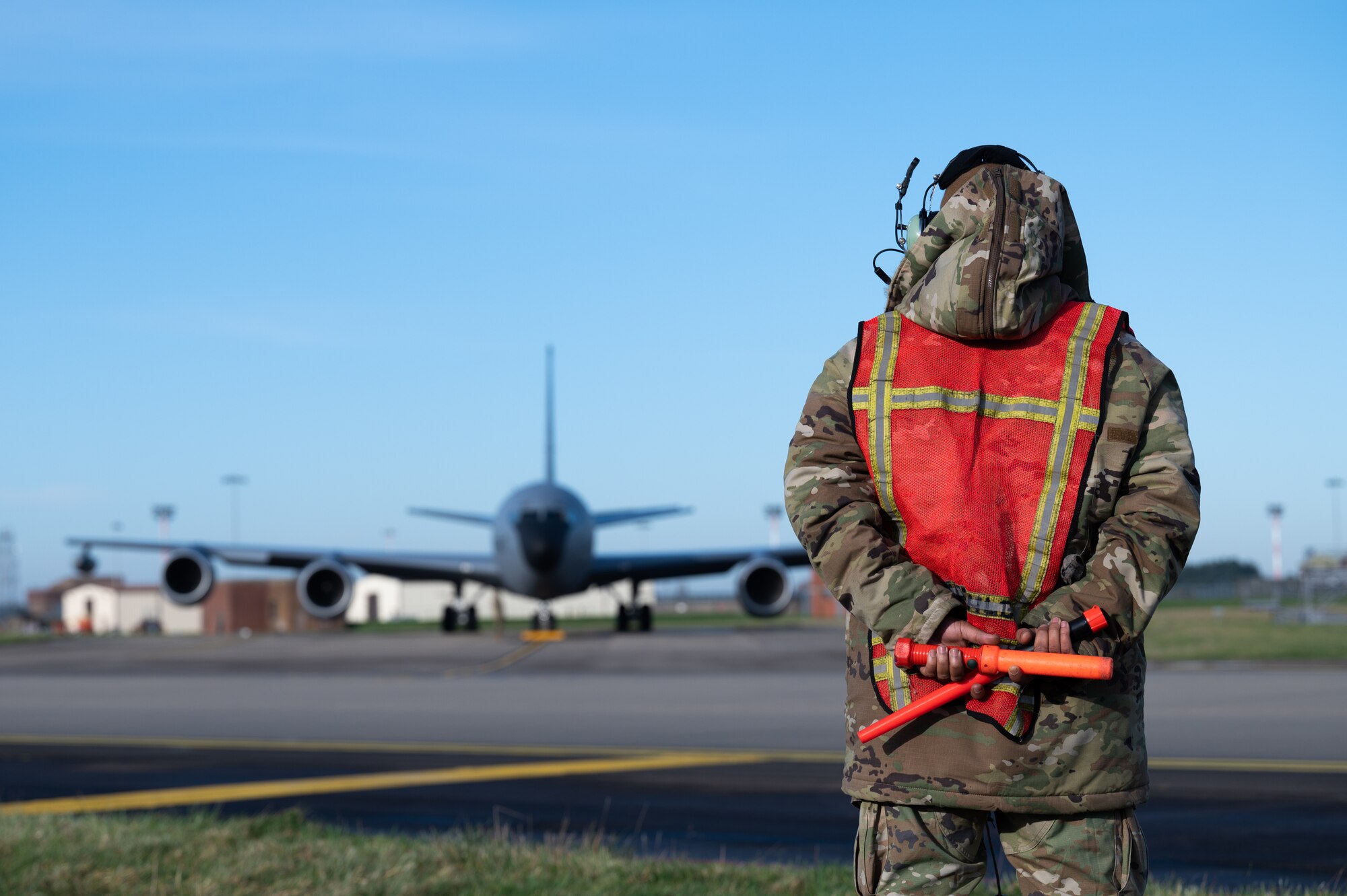 U.S. Air Force Staff Sgt. Marc McLawyer, 100th Aircraft Maintenance Squadron hydraulic technician craftsman, prepares to guide a KC-135 Stratotanker aircraft on the flightline, Jan. 18, 2023, at Royal Air Force Mildenhall, England.