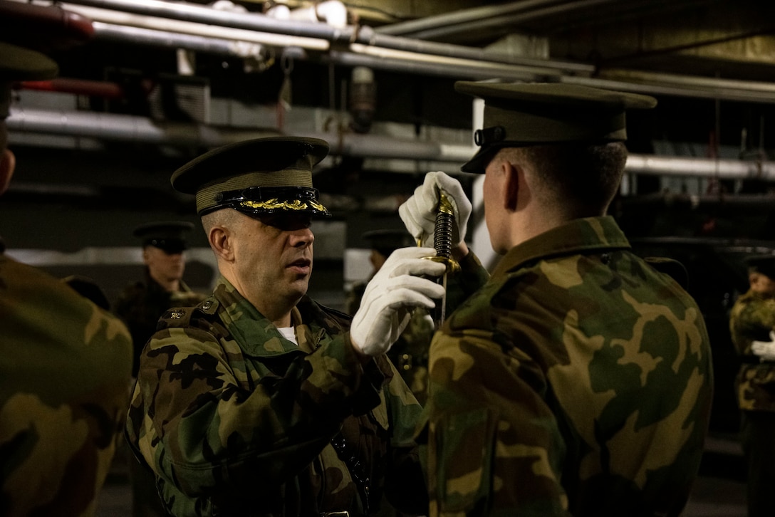 Major Douglas R. Burian, musician, corrects a Marine on the proper way to return a sword during Ceremonial Drill School at Marine Barracks Washington, D.C., Jan 18, 2023. During the 3-week course, Marines will spend countless hours perfecting drill movements to ensure that every Tuesday Sunset Parade and Friday Evening Parade is flawless. (U.S. Marine Corps photo by Cpl. Mark A. Morales)