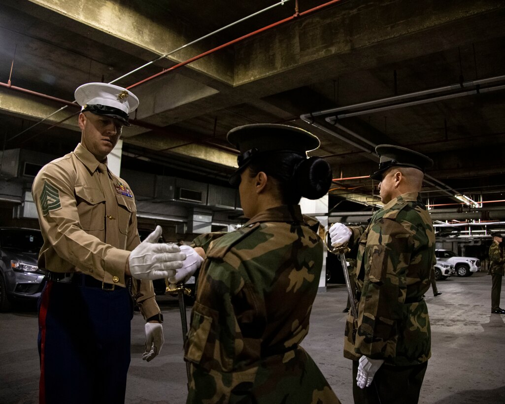 Gunnery Sgt. Thomas C. Brown, company gunnery sergeant, corrects a Marine on the proper way to return a sword during Ceremonial Drill School at Marine Barracks Washington, D.C., Jan 18, 2023. During the 3-week course, Marines will spend countless hours perfecting drill movements to ensure that every Tuesday Sunset Parade and Friday Evening Parade is flawless. (U.S. Marine Corps photo by Cpl. Mark A. Morales)