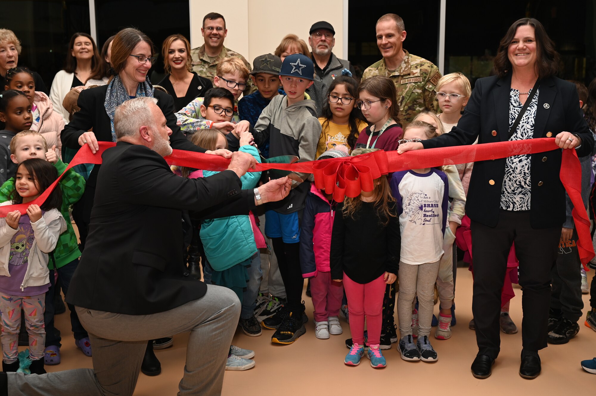 Students from Holloman Elementary cut the grand opening ribbon during the Holloman Elementary School Ribbon Cutting and Open House at Holloman Air Force Base, New Mexico, Jan. 17, 2023. The school is a result of partnerships between Holloman, Alamogordo Public Schools, civic leaders, and state leaders. (U.S. Air Force photo by Airman 1st Class Isaiah Pedrazzini)