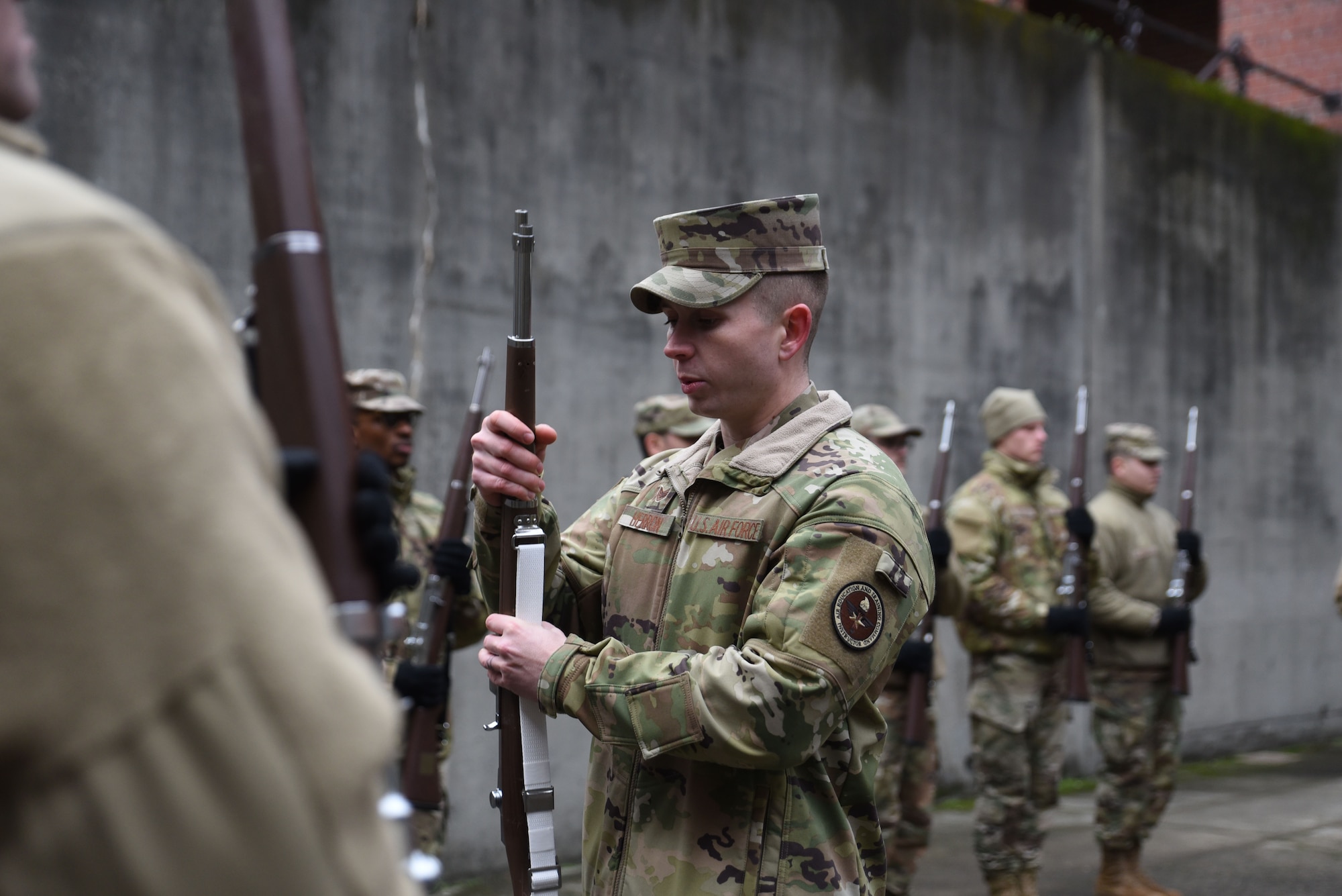 U.S. Air Force Staff Sgt. Jeffery Herron, the non-commissioned officer in charge of formal training with the U.S. Air Force Honor Guard mobile training team, instructs Airmen on proper handling of their training weapon during colors training at Joint Base Lewis-McChord, Washington, Jan. 19, 2023. Herron and three other training instructors traveled to JBLM Joint Base Anacostia-Bolling, Washington D.C¸ to train Honor Guardsmen to standardize all base Honor Guard programs.