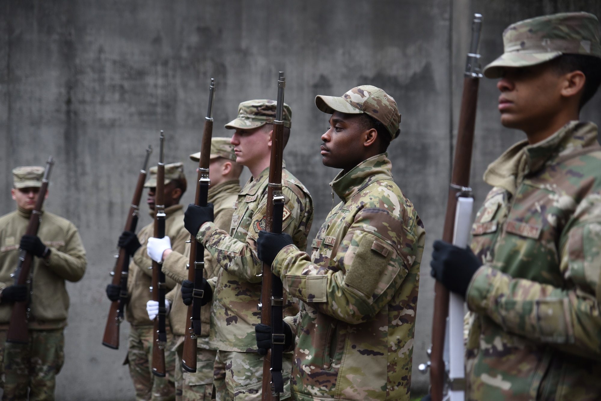 U.S. Airmen from muliple base Honor Guards stand with their weapons at port arms during colors training at Joint Base Lewis-McChord, Washington, Jan. 19, 2023. The U.S. Air Force Honor Guard mobile training team visit bases around the world to train base honor guard Airmen.