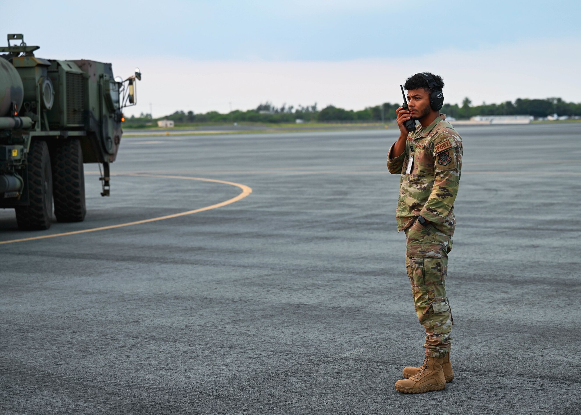 Staff Sgt. Jordan Gilchrist, 735th Air Mobility Squadron air terminal operation center ramp controller, directs a 25th Infantry Division light-medium tactical vehicle into a C-17 Globemaster III at Joint Base Pearl Harbor-Hickam, Hawaii, Jan. 10, 2022. ATOC is the focal point in which all information relating to airlift traffic flow and aerial port operations is received, processed and conveyed to each functional area as well as to the chain of command. (U.S. Air Force photo by Senior Airman Zoie Cox)