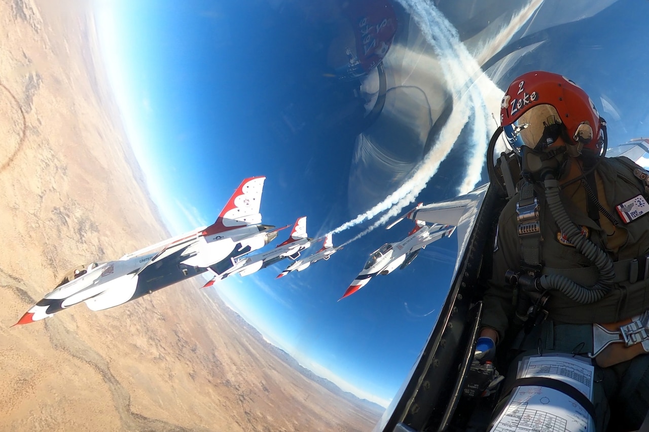 A pilot watches other aircraft go by on the right from the cockpit.