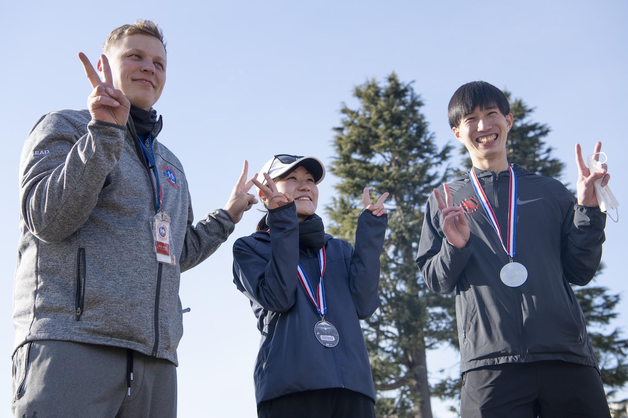 Master Sgt. Tobi Wagner, left, congratulates Mutsumi Nomura, center, and Shogo Akazawa, right, for earning a medal in the men and women’s half-marathon event.