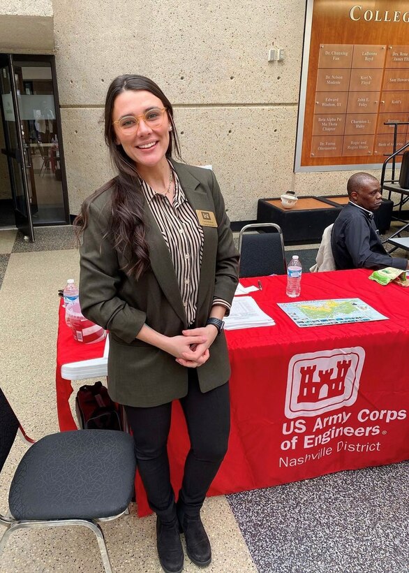 Cierra Vega stands in front of the USACE booth.