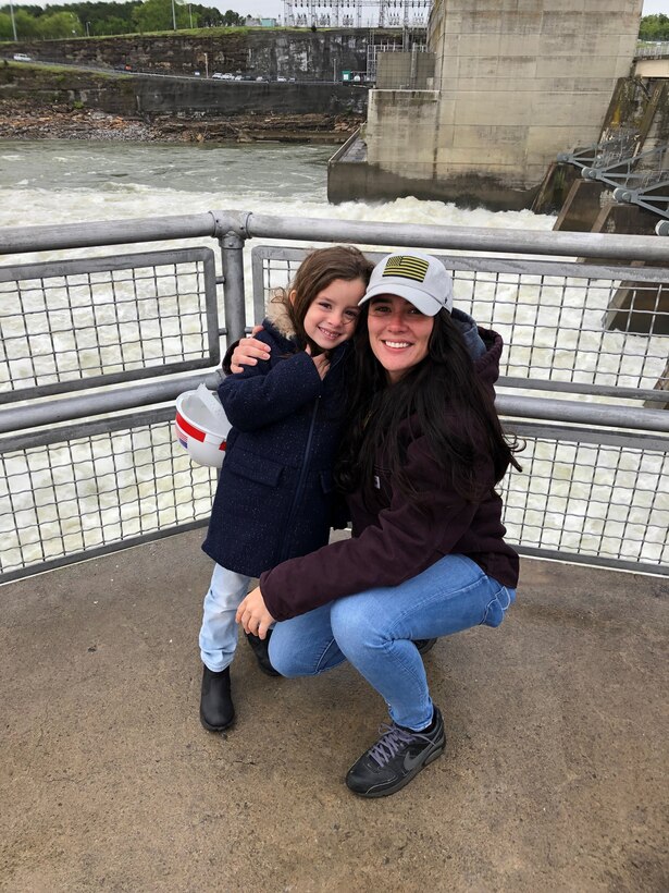 Ciera Vega kneels down in front of Old Hickory Dam with her young daughter.