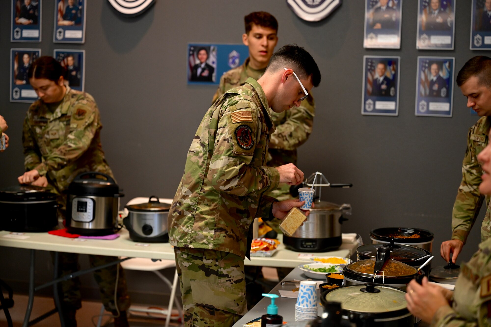 U.S. Air Force Senior Airman Dakota Robinson, 39th Intelligence Squadron intel mission data analyst, goes to taste some chili during the 350th Spectrum Warfare Wing’s first annual Chili Cook Off Competition at Eglin Air Force, Fla., Jan. 17, 2023. The competition was used to raise funds for the wing’s upcoming annual awards ceremony. (U.S. Air Force photo by 1st Lt. Benjamin Aronson)