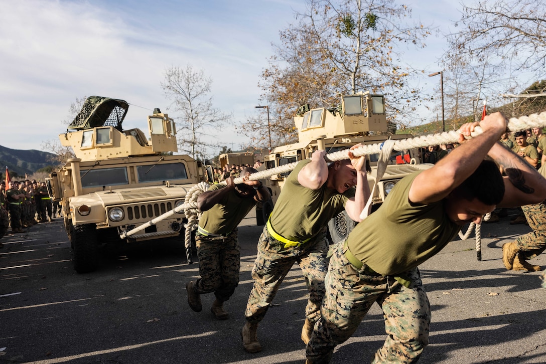 Marines pull a Humvee with a rope.