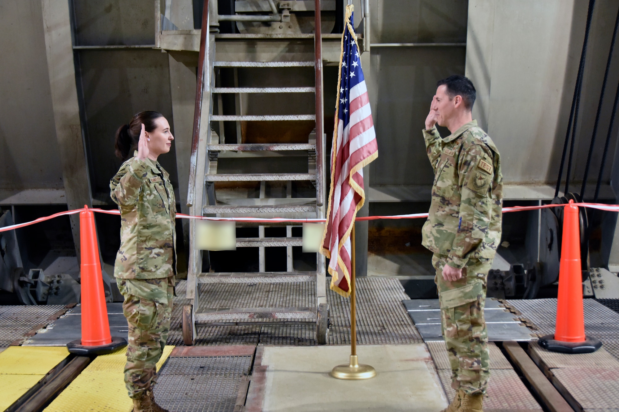 Lt. Col. James Gresham, commander, 716th Test Squadron, right, administers the oath of office to newly-promoted 1st Lt. Camden Dammeyer during a promotion ceremony Nov. 16, 2022, at Arnold Air Force Base, Tennessee. (U.S. Air Force photo by Bradley Hicks) (Images have been altered by obscuring test cell signage.)