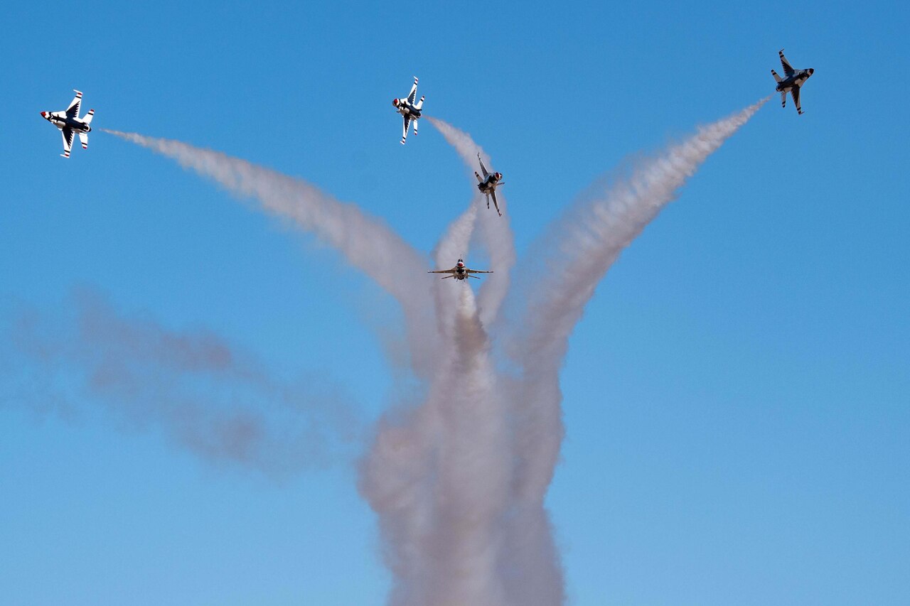 Aircraft fly through the air as jet streams trail behind.