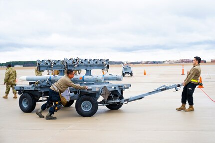 Airmen transport missile rack to loading station.