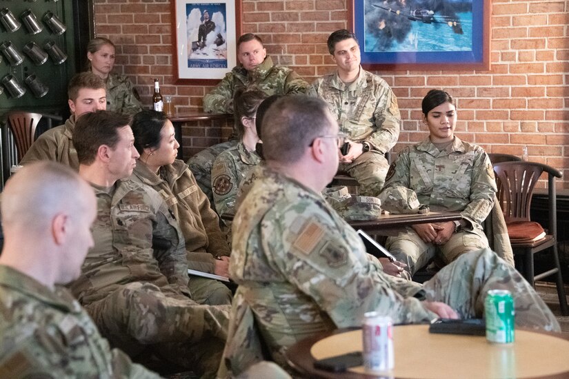 A military member talks to a crowd of other military members.