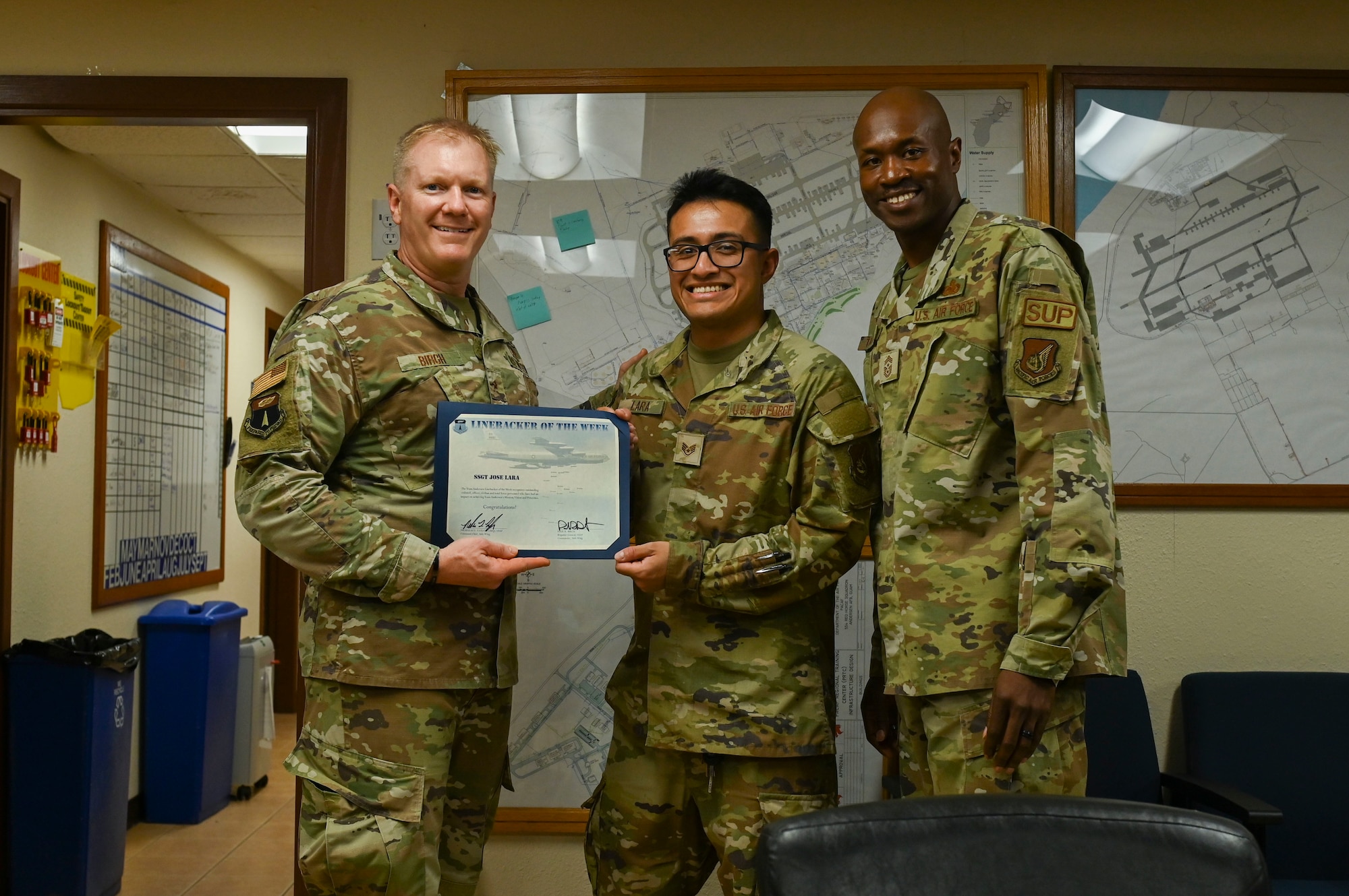 Three people pose with a certificate