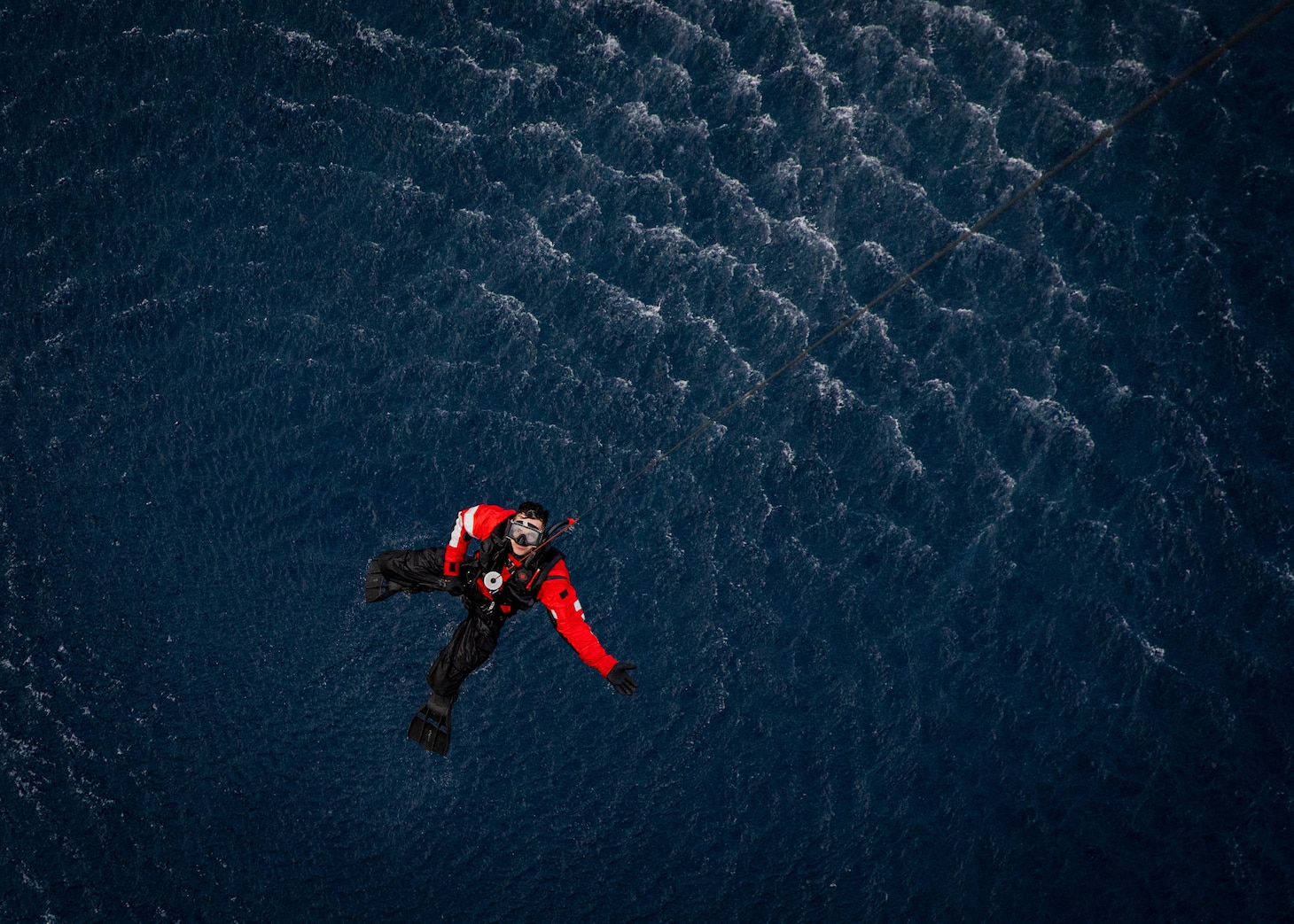 Naval Air Crewman (Helicopter) 3rd Class Christian Pedro, assigned to Helicopter Sea Combat Squadron (HSC) 5, is raised out of the water during a combat search and rescue training evolution, Jan. 19, 2023.