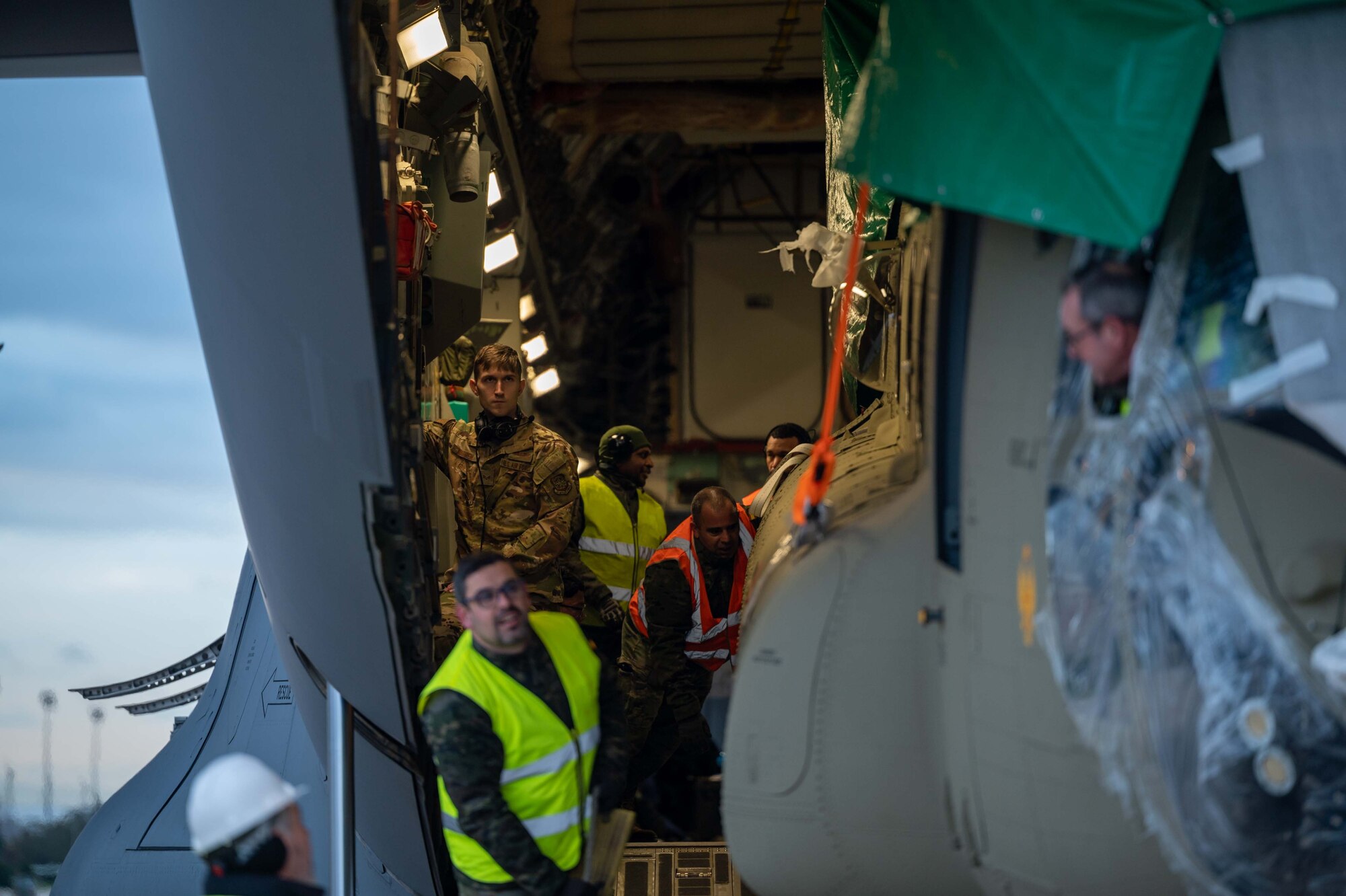 Senior Airman Matthew Warren, 3rd Airlift Squadron loadmaster, controls the wench system while unloading a CH-47F Chinook helicopter from a C-17 Globemaster III assigned to Dover Air Force Base, Delaware, during a foreign military sales mission at Torrejón Air Base, Spain, Jan. 16, 2023. The United States and Spain recognize the central importance of the NATO alliance in ensuring transatlantic peace and security. As NATO Allies for 40 years, the U.S. and Spain are steadfastly committed to providing NATO with ready forces and capabilities, strengthening transatlantic ties. (U.S. Air Force photo by Senior Airman Faith Barron)