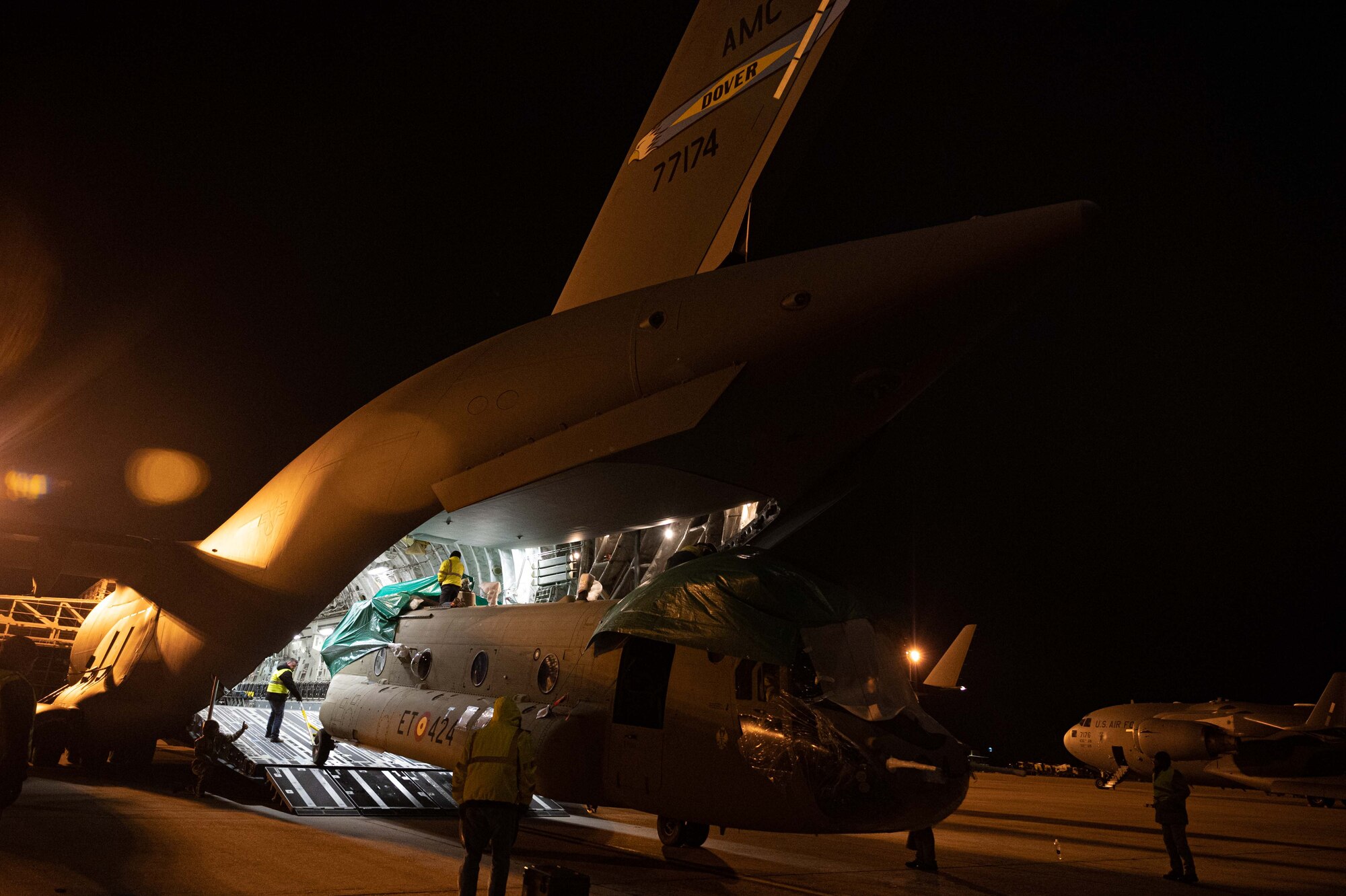 Team Dover Airmen load a CH-47F Chinook helicopter onto a C-17 Globemaster III during a foreign military sales mission at Dover Air Force Base, Delaware, Jan. 14, 2023. The C-17 transported a CH-47 to the Spanish army as a part of the Department of Defense’s FMS program. Spain, a member of NATO, promotes democratic values and encourages consultation and cooperation on defense and security issues to build trust and prevent conflict. (U.S. Air Force photo by Senior Airman Faith Barron)