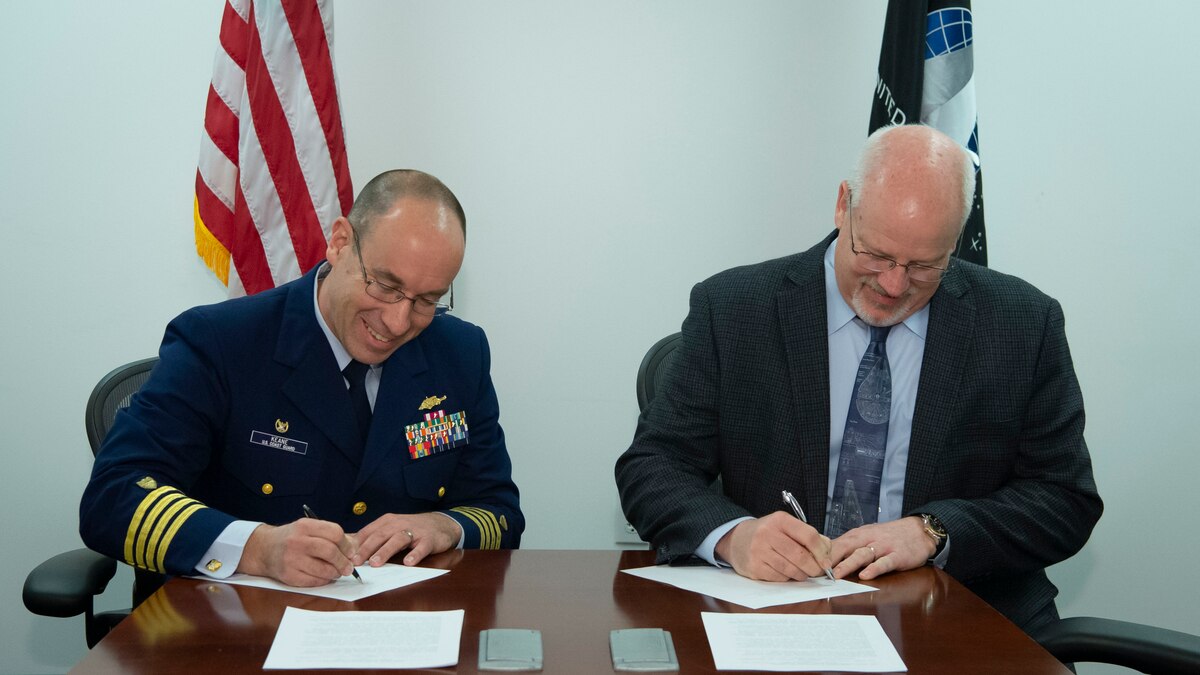 Dr. Joel Mozer, United States Space Force Director of Science, Technology and Research, and U.S. Coast Guard Capt. Dan Keane, Coast Guard Research and Development Center commanding officer, sign a Memorandum of Understanding to enhance space-related capabilities for the joint warfighter. This MOU aims to develop a partnership that focuses on coordination, collaboration, and transparency to enhance capabilities and technologies, and to share best practices. (U.S. Air Force photo by Staff Sgt. Stuart Bright)