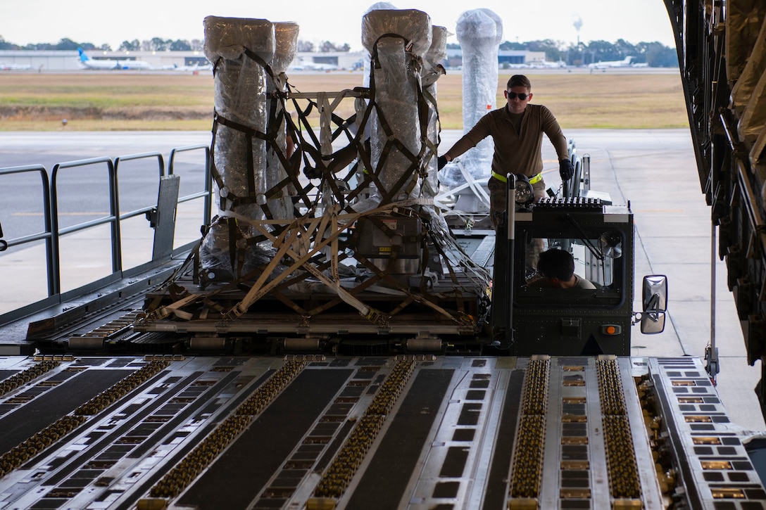An airman loads power equipment onto a C-17 Globemaster III.