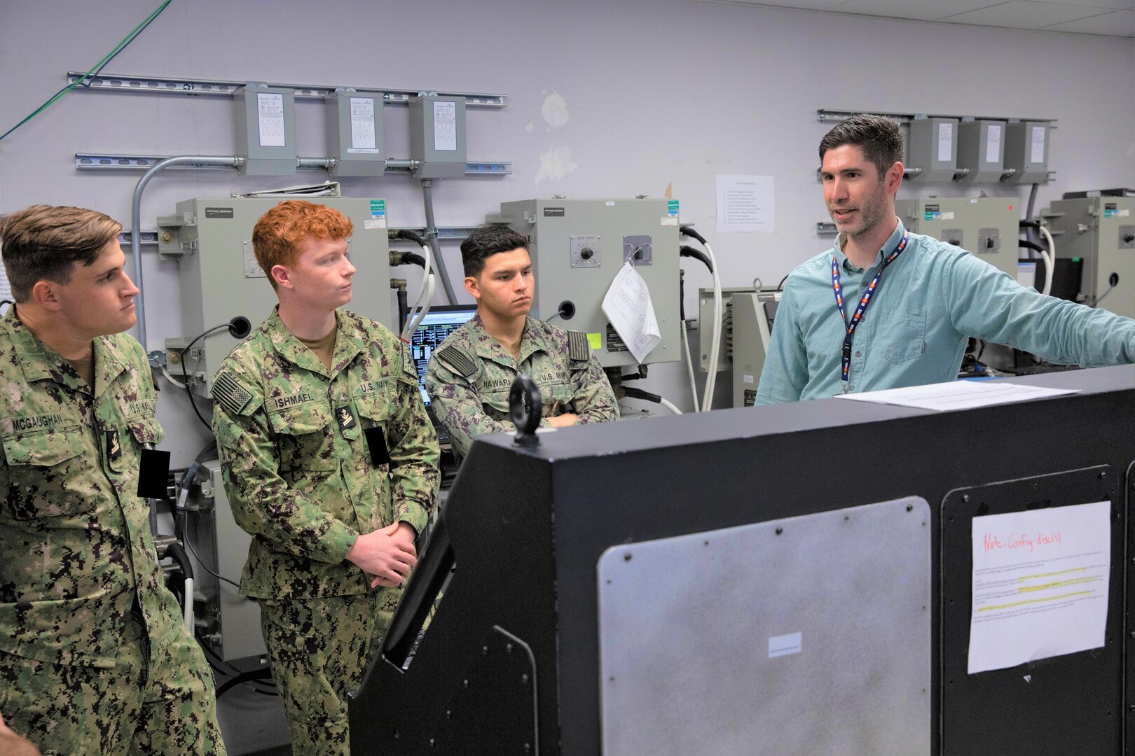 Daniel Weissgerber (far right), an electrical engineer at Naval Surface Warfare Center, Philadelphia Division (NSWCPD) discusses the Integrated Bridge Navigation System with U.S. Naval Academy students assigned to the Naval Architecture and Ocean Engineering (EN) 350 Marine Engineering Systems Class; (from left) Midshipman 2nd class Brandon McGuaghan, Midshipman 2nd class Ishmael Ian, and Midshipman 2nd class Liam Nawara. The Naval Academy students visited NSWCPD on Oct. 26, 2022 to gain on-site experience with different naval technologies.