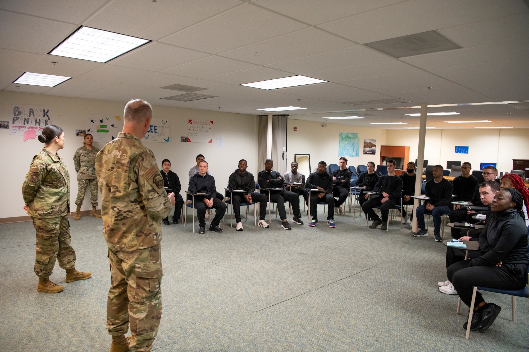 Man and woman in OCP uniforms speaks to students in a classroom