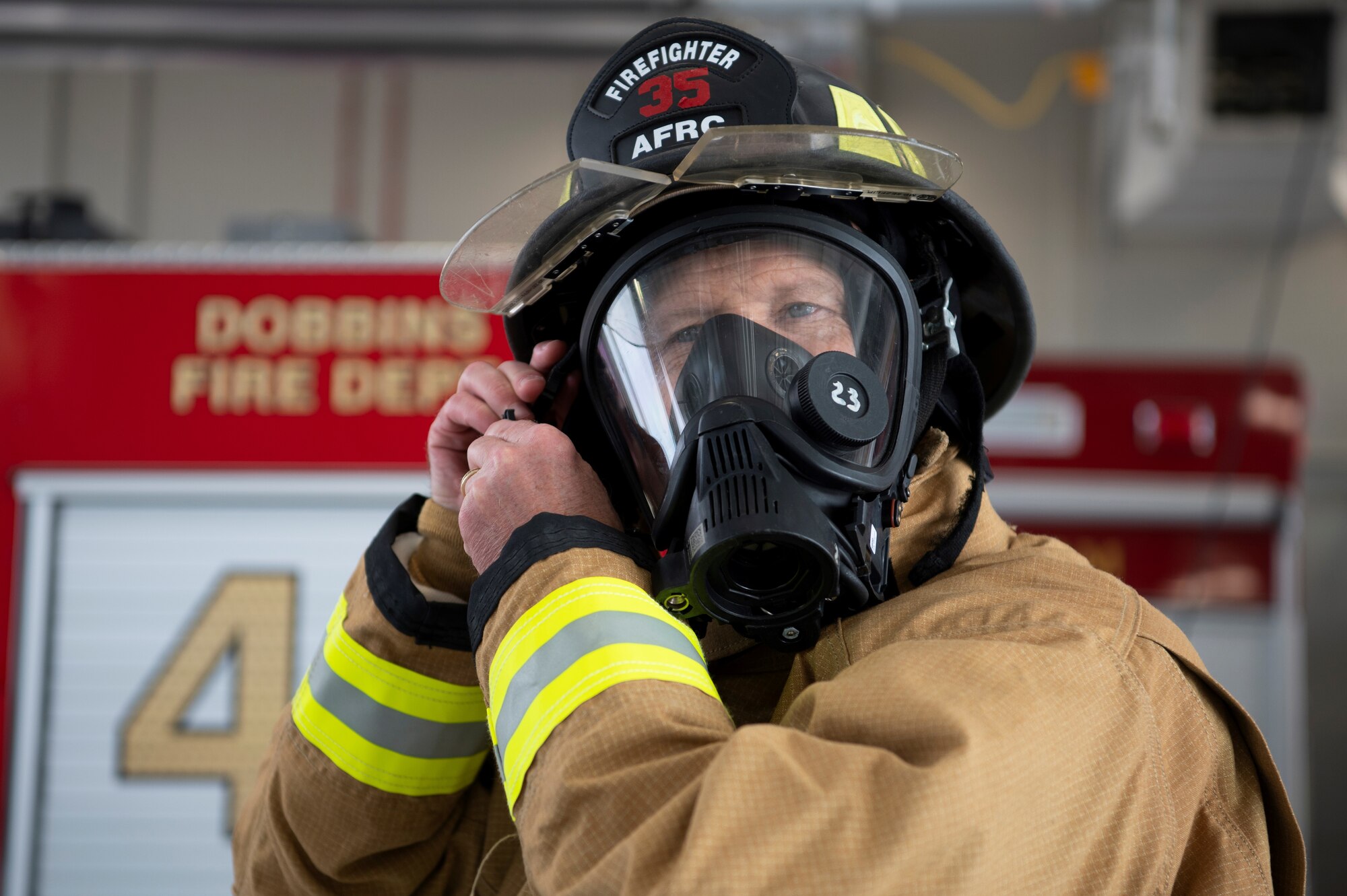 Man puts on mask while visiting a fire station for a tour