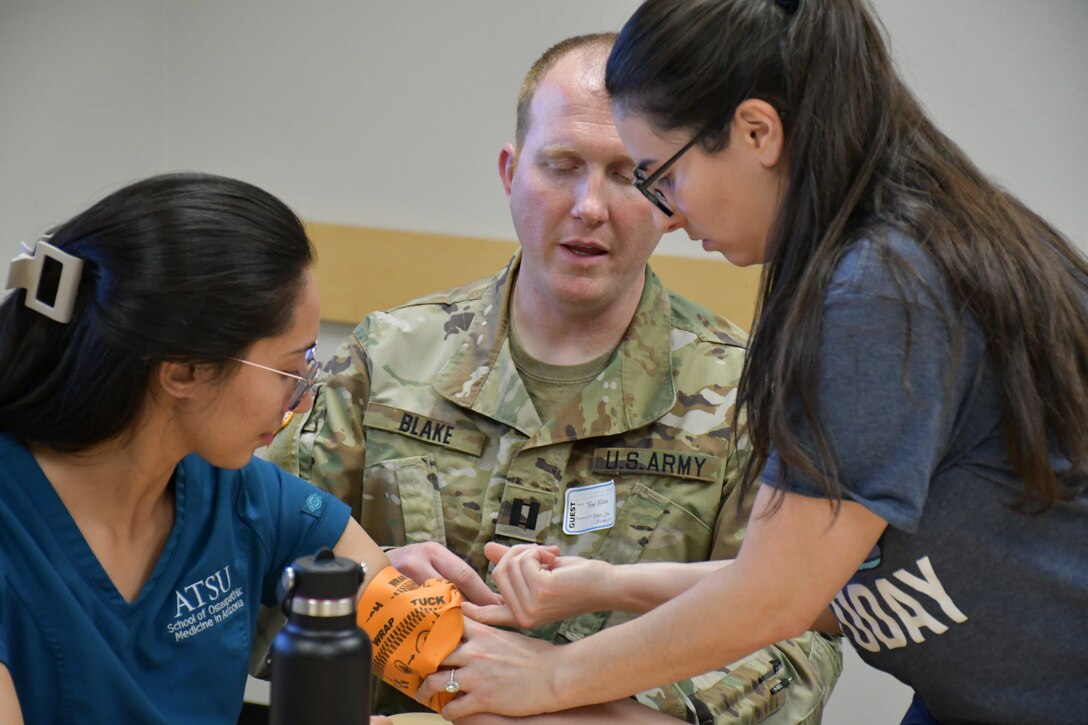 A student from the AT Still University School of Osteopathic Medicine cares for a simulated infant victim while his team briefs 1st Lt. Christina Kmotorka on the status of another patient. (US Army photo by Tim Dewar)