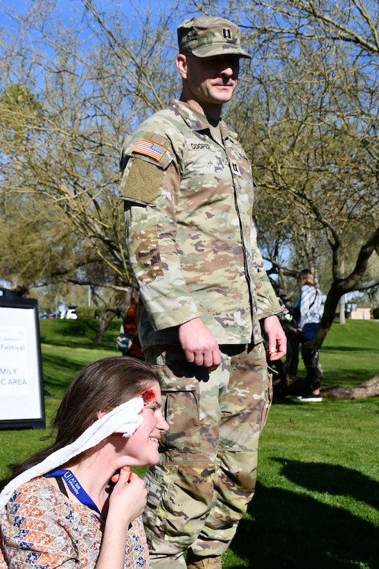 A student from the AT Still University School of Osteopathic Medicine cares for a simulated infant victim while his team briefs 1st Lt. Christina Kmotorka on the status of another patient. (US Army photo by Tim Dewar)