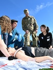 A student from the AT Still University School of Osteopathic Medicine cares for a simulated infant victim while his team briefs 1st Lt. Christina Kmotorka on the status of another patient. (US Army photo by Tim Dewar)