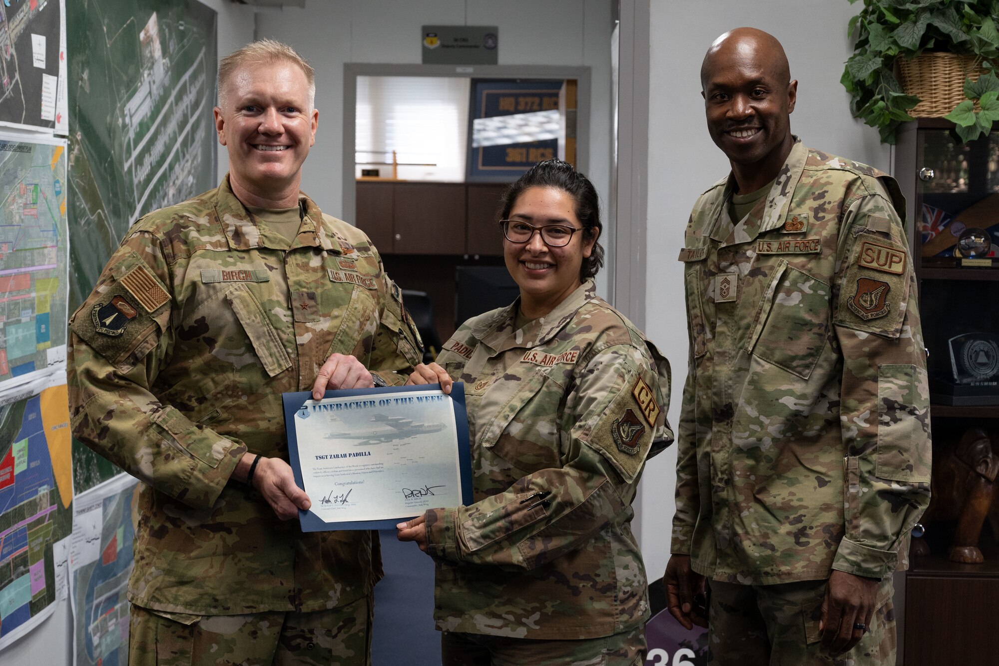 U.S. Air Force Tech. Sgt. Zarah Padilla, the commander’s executive assistant assigned to the 36th Contingency Response Group, receives the Linebacker of the Week Award from U.S. Air Force Brig. Gen. Paul Birch, commander of the 36th Wing, and U.S. Air Force Chief Master Sgt. Nicholas Taylor, the command chief of the 36th Wing, at Andersen Air Force Base, Guam, Jan. 18, 2023. The Team Andersen Linebacker of the Week recognizes outstanding enlisted, officer, civilian and total force personnel who have had an impact on achieving Team Andersen’s mission, vision and priorities. (U.S. Air Force photo by Airman 1st Emily Saxton)